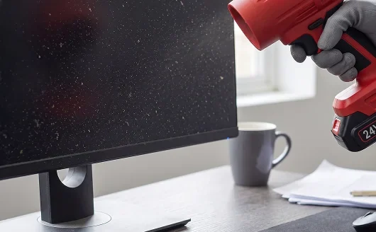 Dusting a desk and monitor on a light setting